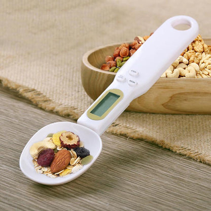 LCD digital kitchen scale with LCD display showing internal mechanism and removable battery cover.