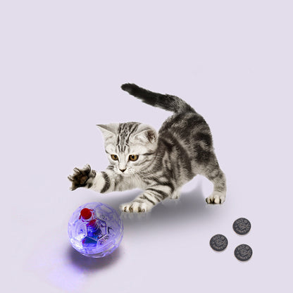 A playful kitten reaching for a glowing cat toy ball during interactive playtime.
