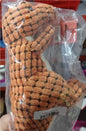 Close-up of a person squeezing a soft dinosaur squeaky dog toy in orange color.