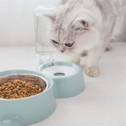 Cat curiously inspecting an automatic dog water bowl with stainless steel bowl and food compartment.