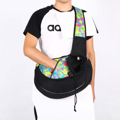 Person wearing a colorful pet crossbody carrier bag designed for outdoor use with dogs and cats.