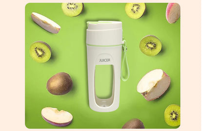 Portable USB blender cup surrounded by fresh fruits on a green background, showcasing its convenience for smoothies.