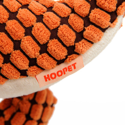 Close-up of a person squeezing a soft dinosaur squeaky dog toy in orange color.