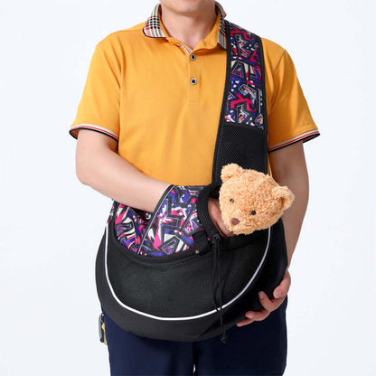 Man holding a colorful pet crossbody carrier bag with a plush toy inside for dogs and cats.