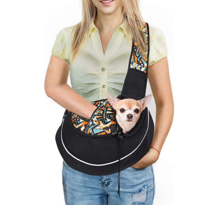 Woman using a pet crossbody carrier bag to comfortably hold a small dog during outdoor activities.